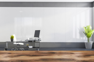 Table in blurry white and grey CEO office