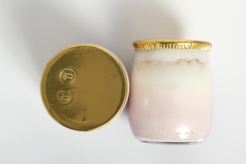 Yogurt in small glass jar with aluminum foil seal cap. Isolated