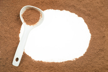 Tasty cocoa powder in spoon isolated on white background.