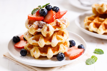 belgian waffles with fresh blueberries, strawberries and sugar.