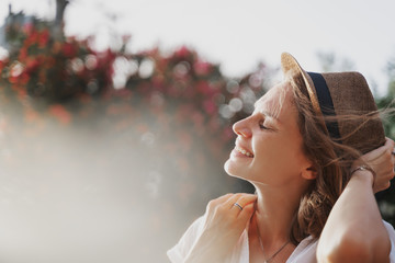 Portrait of a beautiful young stylish woman in a white shirt, a hat laughing joyfully, summer mood...