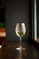 Elegant glass of white wine on wooden bar counter