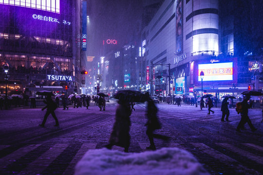 Crowd On Snow Covered Street Amidst Illuminated City At Night