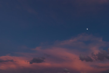 夕焼けにたなびく雲と月