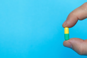 Male hand holds a pill. Pharmaceutical medicine