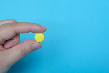 Female hand holds a pill. Pharmaceutical medicine