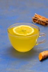 Daily detox lemon, ginger and turmeric tea in a glass cup