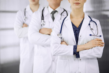 Doctors standing as a team with arms crossed in clinic. Medical help, insurance and medicine concept