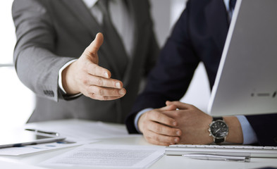 Business people using computer while working together in modern office. Unknown businessman or male entrepreneur with colleague at workplace. Teamwork and partnership concept