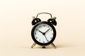 black retro alarm clock on a beige background