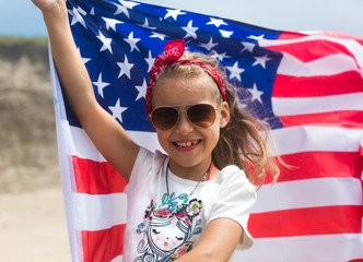 Young girl holding american flag on Independence Day, July 4th. USA