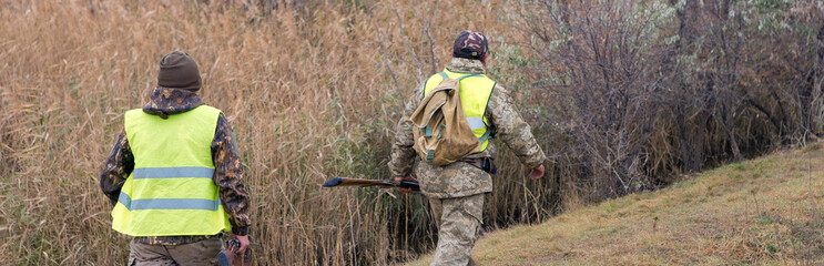 Hunters with a german drathaar and spaniel, pigeon hunting with dogs in reflective vests