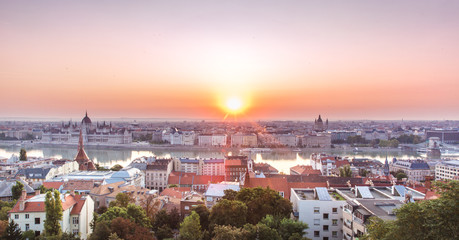 Obraz premium Panoramic cityscape of Hungarian parliament building and Saint Stephen basilica on the Danube river. Colorful sunrise in Budapest, Hungary