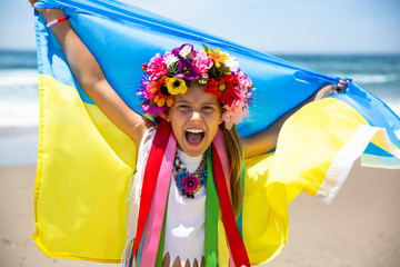 Young girl shouting with national flag of Ukraine above the head. Blue and yellow Ukrainian flag is a symbol of the country strength and independence