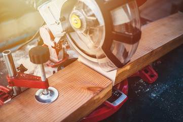 Works miter saw. The black line in the place of the future cut. The hand of a carpenter man controls the saw. Works miter saw close up.