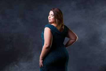 Fototapeta na wymiar Plus size fashion model in green evening dress, fat woman on black background