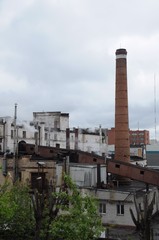 Fototapeta na wymiar Many smoking chimneys and factory buildings