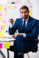 Young male employee in conflicting priorities concept