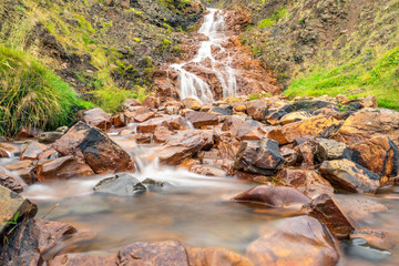 Red rocks and beautiful exotic waterfall cascade at Hvitserkur in Vatnsnes peninsula in Iceland....