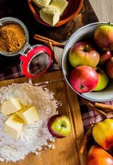 Ingredients for the preparation of the pie lie on a table covered with a rustic cloth