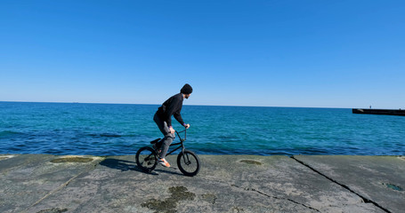 Fototapeta premium Young male with bmx bicycle ride near the sea