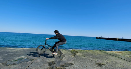 Young male with bmx bicycle ride near the sea