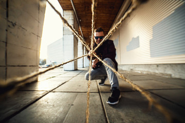 Creative photo of a man releases from a thread in all directions in the urban background. Wide...