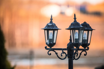 Fototapeta na wymiar Black lantern lamp post with blurry background
