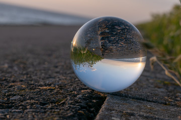 Sunset over the sea seen through a glasball