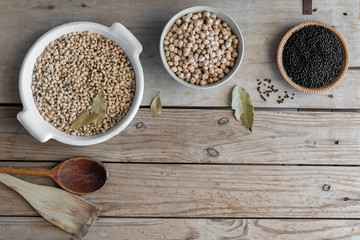 different legumes on a wooden background with the space for your text (black lentils , chick peas , beans )