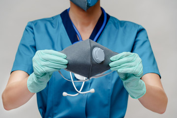female doctor with stethoscope wearing protective mask and latex gloves over light grey background