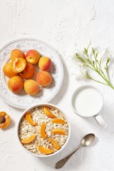 breakfast with oatmeal and apricot with milk. Summer season, fresh fruits, copy space