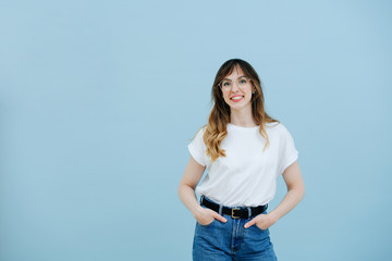 Girl with long hair in large glasses with diopters in a white T-shirt and jeans