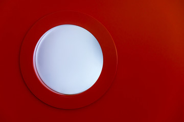 Red door and porthole with copy space.