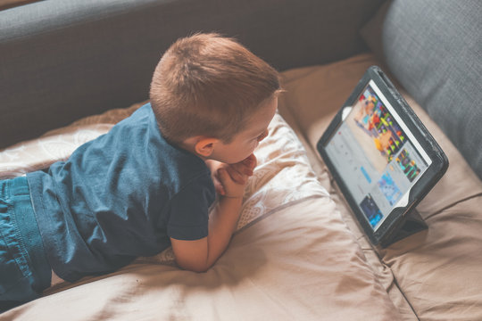 Young Child Boy Watching Cartoon on Tablet in the Couch
