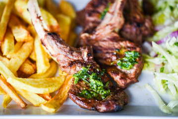 delicious grilled lamb chopsticks with french fries, pesto sauce & mix of lettuces