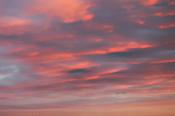 Naklejka na ściany i meble Dreamy romantic sky with clouds at sunset in orange.