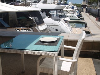 Sunny day at the yacht club and cafe waiting for guests. The served table. Empty dishes and cutlery...