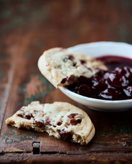 Cranberry cookies with jam on rustic wooden background. Close up.