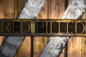 Photo of real authentic typeset letters forming Red Pilled text with on vintage textured silver...