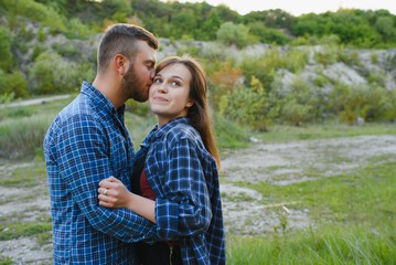 Couple enjoying beautiful views on the mountains, while traveling with backpacks in the mountains during the summer vacations