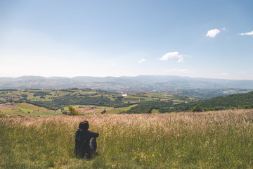 Femme assise devant panorama sur le mont pilat