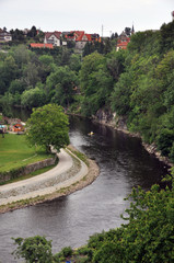 Fototapeta na wymiar A bend and a fragment of the embankment of the Vltava River in the historical part of Cesky Krumlov.