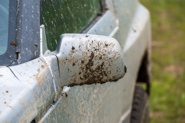 Dirty, mudy side mirror on off road vehicle close up shot.