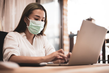 Young woman are working on laptops on old wooden tables blurred at home, protection from viruses..Stay home. Quarantine. World pandemic...