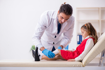 Small girl visiting young male doctor