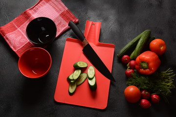 Cutting vegetables on a kitchen board. Preparing or cooking salad
