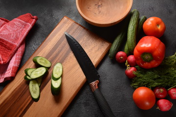 Cutting vegetables on a kitchen board. Preparing or cooking salad
