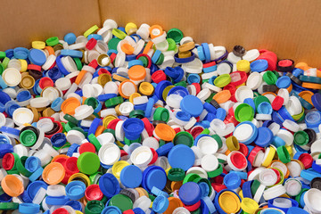 Fototapeta na wymiar Plastic recycle. Sorting garbage. Waste recycling. Waste recycling plant. Colorful plastic bottle caps background. Colorful background of bottle caps. Recyclable waste concept. Material for processing