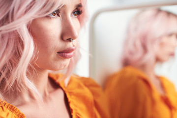 Pretty young woman with reflection in mirror